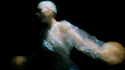 A translucent human torso and head made of flowing particles and iridescent dots leans forward against black void, arms extended toward two golden spherical clusters, the body dissolving into cyan and amber point clouds.