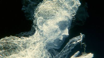 An afterimage dissolving into horizontal scanlines: a face in profile and shoulders made of white-blue threads of text break apart against black, a hand at lower right still holding a small key-like tool.